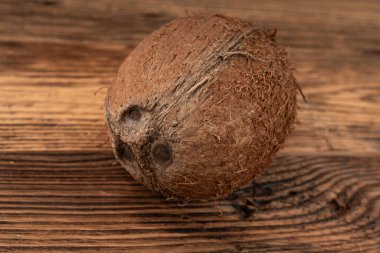 Tam hindistan cevizi, bir hindistan cevizi, tek taze tropikal palmiye meyvesi, doğal süt, doğal ahşap arka planda yağ bileşeni.