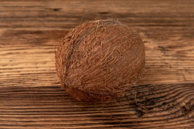 Tam hindistan cevizi, bir hindistan cevizi, tek taze tropikal palmiye meyvesi, doğal süt, doğal ahşap arka planda yağ bileşeni.