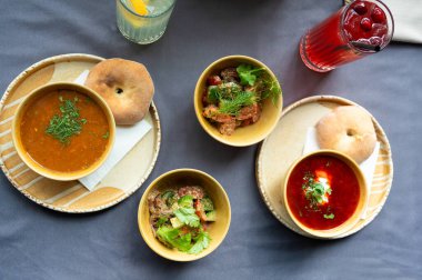 Masada servis edilen çorba, salata, ekmek ve içeceklerle yapılan geleneksel öğle yemeğinin en üst görüntüsünde taze malzemeler ve seramik kaseler ve tabaklar içinde kırsal sunum yer alıyor.