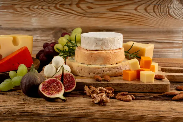 Peynir tabağı çeşitliliği, sarı, beyaz ve mavi gorgonzola tabağı, Munster, dört peynirli pano, çeşitli doğranmış süt ürünleri, ahşap üzerinde kokulu Fransız peyniri.