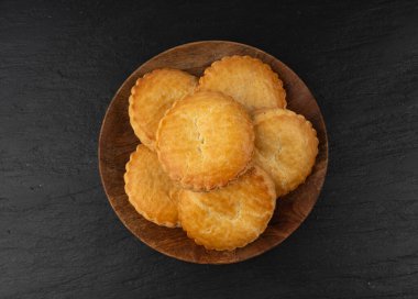 Hollanda geleneksel kurabiyeleri, Hollanda bademi dolgulu pasta, Hollanda badem ezmeli pasta, gevulde koek veya fındık ezmeli tart, siyah arka planda Breton tereyağlı bisküvi