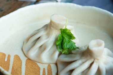 Gürcistan usulü khinkali ya da Çin usulü kıymalı. Geleneksel baharatlı Gürcü buğulama hamur köftesi, bir restoran tabağında servis edilen gamsum, momo, jiaozi, manti, pierogi veya wonton 'a benzer.