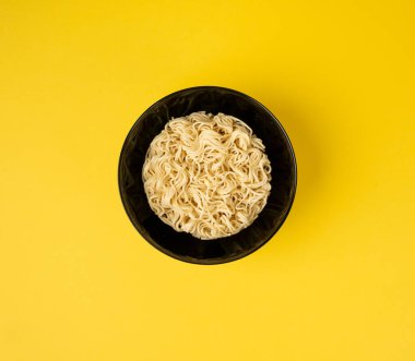 Çiğ erişte, yuvarlak Ramen Eriştesi Kasede, pişmemiş Kore Vermicelli, Hızlı Çin Buğday Makarnası, Sarı Arka plan Üst Görüş Anında Anında Makarna