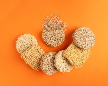 Çeşit çeşit Çiğ Erişte, Kupa 'da Kuru Yuvarlak Ramen Eriştesi, Farklı Pişmemiş Kore Vermicelli, Hızlı Çin Buğday Makarnası, Turuncu Arka plan Üst Görünüm' de Anında Makarna Karışımı