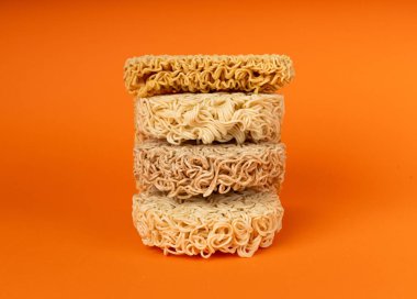 Çiğ Erişte Yığını, Kuru Yuvarlak Ramen Eriştesi Seti, Pişmemiş Kore Vermicelli, Hızlı Çin Çavdar ve Buğday Makarnası, Turuncu Arkaplanda Hazır Makarna