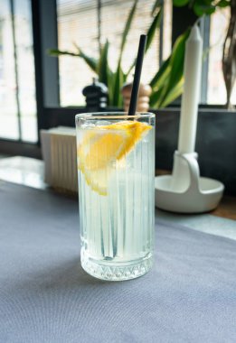 Büyük bardakta buzlu limonata. Limonlu ve gazozlu Yuzu moktail, restoran masasında soğuk limon suyu kokteyli, yaz zamanı taze detoks içeceği.