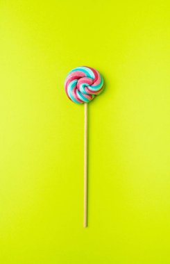 Renkli lolipop, çubukta sarmal şeker, renkli çizgili lolipop, yuvarlak meyveli karamel, çok renkli şekerleme, yeşil arka planda daire lolipop, metin için kopyalama alanı
