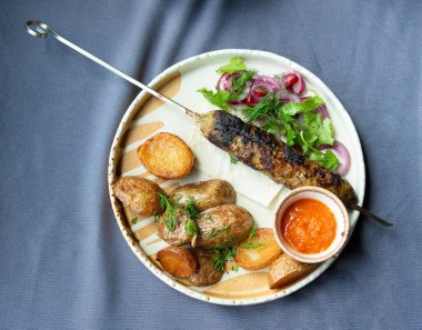 Gürcistan lula kebap tabağı. Barbekü şiş, geleneksel barbekü tabağı fırında patates ve salata. Izgara souvlaki, kıyma kebap, sofrada koyun eti lula, şişte ızgara kuzu.