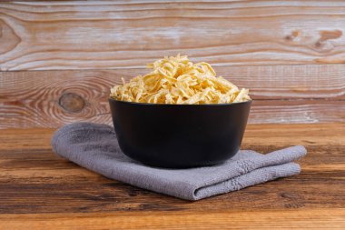 Passatelli spatzle makarna kasede, çiğ spaetzle noodle, ev yapımı Alman makarnası, ahşap masa arkasında sahanda yumurta makarna.
