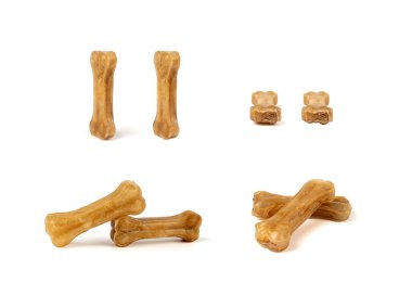 Rawhide kemikleri izole edilmiş, kolajen köpek yiyecek çiğniyor, kurutulmuş köpek maması çiğniyor, beyaz arka planda kemikler halinde uzun ömürlü köpek bakımı yapılıyor.
