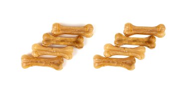 Rawhide kemikleri izole edilmiş, kolajen köpek yiyeceği çiğniyor, kurutulmuş mamayı çiğniyor, uzun ömürlü köpek dişleri, beyaz arka planda kemikler şeklinde tedavi görüyor.