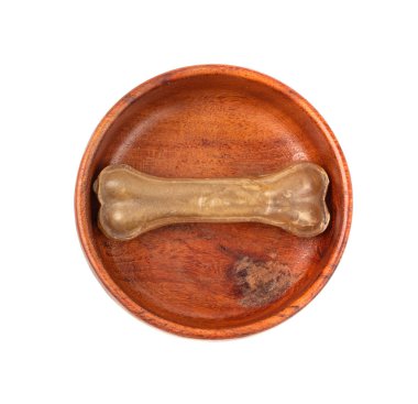 Kâsedeki bir rawhide kemiği izole edilmiş, tek bir kolajen köpek çiğnenmiş yiyecekler, ezilmiş kuru mama, uzun ömürlü köpek dişleri, beyaz arka planda kemikler şeklinde tedaviler.