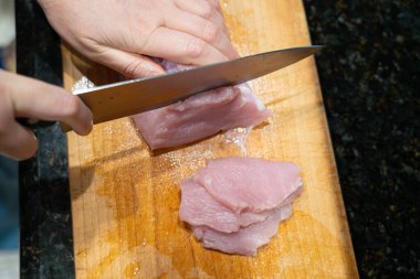 Çiğ hindi fileto nugget veya escalope için dilimleme, mutfak bıçağıyla et kesme, ev yapımı şnitzel pişirme süreci yakın çekim