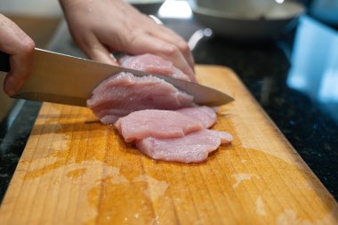 Çiğ hindi fileto nugget veya escalope için dilimleme, mutfak bıçağıyla et kesme, ev yapımı şnitzel pişirme süreci yakın çekim
