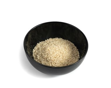 Siyah kasedeki susam tohumları izole edilmiş, beyaz küçük benne taneleri, beyaz arka planda susamum indium meyveleri yığılmış.