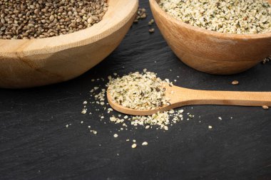 Kabuklu kenevir tohumları, soyulmuş kenevir taneleri, kabuksuz marihuana çekirdekleri, siyah arka planda yağlı protein kenevir tohumları.