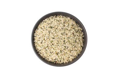 Kabuklu kenevir tohumları siyah kasede, soyulmuş kenevir taneleri, kabuksuz marihuana çekirdekleri, beyaz arka plan görünümlü yağ proteini kenevir tohumları yığını.