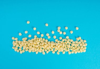 Beyaz çikolata parçaları, dağınık beyaz çikolata serpintileri, dekoratif kakao damlaları, Morsels, Kurabiye Dekorasyonu, Mavi Arkaplan Üst Görüş 'te Küçük Şekerleme Çipleri Parçaları