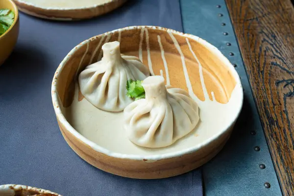 Gürcistan usulü khinkali ya da Çin usulü kıymalı. Geleneksel baharatlı Gürcü buğulama hamur köftesi, bir restoran tabağında servis edilen gamsum, momo, jiaozi, manti, pierogi veya wonton 'a benzer.