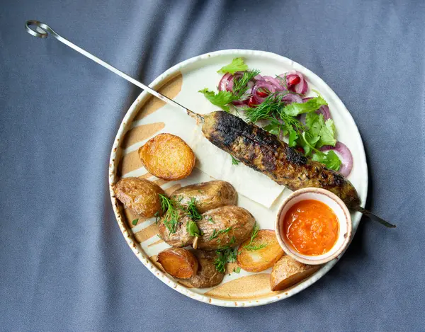 Gürcistan lula kebap tabağı. Barbekü şiş, geleneksel barbekü tabağı fırında patates ve salata. Izgara souvlaki, kıyma kebap, sofrada koyun eti lula, şişte ızgara kuzu.