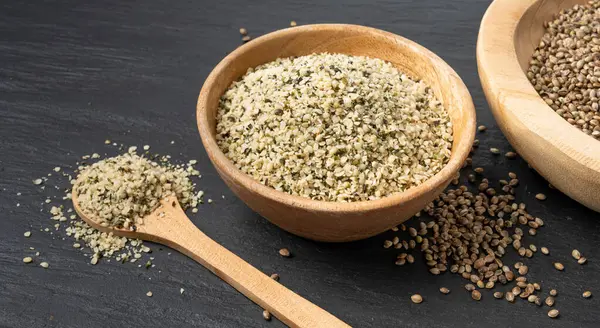 Kabuklu kenevir tohumları, soyulmuş kenevir taneleri, kabuksuz marihuana çekirdekleri, siyah arka planda yağlı protein kenevir tohumları.