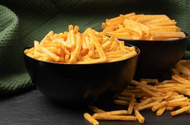 Kızarmış cips çubukları siyah kasede, parmak patates cipsi, altın ayakkabı teli patates kızartması, patates kızartması, patates kızartması, saçılmış patates kızartması...
