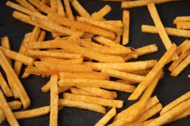 Patates kızartması, patates kızartması, patates kızartması, patates kızartması, patates kızartması, siyah arka planda patates kızartması.