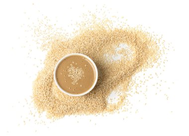 Tahini kasede izole edilmiş, susam tohumu ezmesi sürülmüş tahina sosu, doğu sosu, geleneksel doğu mutfağı malzemesi, beyaz arka planda yer susamı.