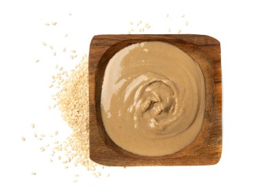 Tahini kasede izole edilmiş, susam tohumu ezmesi sürülmüş tahina sosu, doğu sosu, geleneksel doğu mutfağı malzemesi, beyaz arka planda yer susamı.