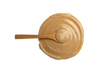 Tahini yuvarlak smear izole edilmiş, susam tohumu macunu sıçramış, tahina sosu dökülmüş, doğu sosu dökülmüş, geleneksel doğu mutfağı dairesel damla, zemin susamı beyaz arka planda.