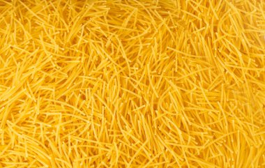 Çiğ vermicelli desenli arka plan, altın çorbalı makarna deseni, küçük ev yapımı erişte makarnası, ince makarna pankartı, metin için fotokopi alanı olan İtalyan sarı makarna.
