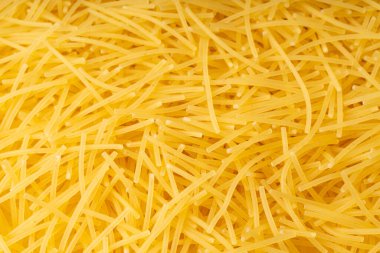 Çiğ vermicelli desenli arka plan, yakın plan, altın çorbalı makarna deseni, küçük ev yapımı erişte makarnası makarnası, ince makarna pankartı, metin için fotokopi alanı olan İtalyan sarı makarna makarnası.