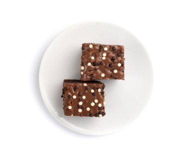 Çikolatalı kek izole edilmiş beyaz ve koyu renkli toplar serpiştirilmiş, beyaz arka planda tatlı jöleli klasik doğum günü browni karesi.