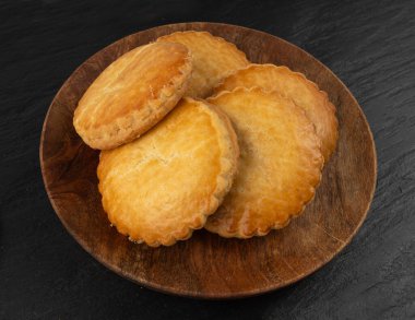 Hollanda geleneksel kurabiyeleri, Hollanda bademi doldurulmuş pasta, Hollanda badem ezmeli pasta, gevulde koek veya fındık ezmeli tart, siyah arka planda Breton tereyağlı bisküvi