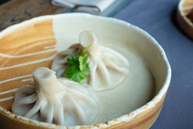 Gürcistan usulü khinkali ya da Çin usulü kıymalı. Geleneksel baharatlı Gürcü buğulama hamur köftesi, bir restoran tabağında servis edilen gamsum, momo, jiaozi, manti, pierogi veya wonton 'a benzer.