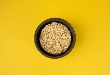 Çiğ erişte, yuvarlak Ramen Eriştesi Kasede, pişmemiş Kore Vermicelli, Hızlı Çin Buğday Makarnası, Sarı Arka plan Üst Görüş Anında Anında Makarna