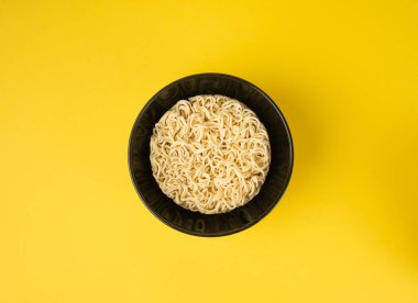 Çiğ erişte, yuvarlak Ramen Eriştesi Kasede, pişmemiş Kore Vermicelli, Hızlı Çin Buğday Makarnası, Sarı Arka plan Üst Görüş Anında Anında Makarna