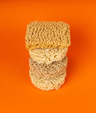 Çiğ Erişte Yığını, Kuru Yuvarlak Ramen Eriştesi Seti, Pişmemiş Kore Vermicelli, Hızlı Çin Çavdar ve Buğday Makarnası, Turuncu Arkaplanda Hazır Makarna