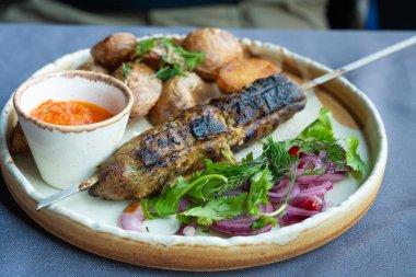 Gürcistan lula kebap tabağı. Barbekü şiş, geleneksel barbekü tabağı fırında patates ve salata. Izgara souvlaki, kıyma kebap, sofrada koyun eti lula, şişte ızgara kuzu.