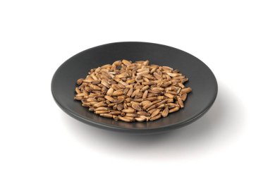 Milk thistle seeds isolated, silybum marianum grains, dry blessed milkthistle fruits, variegated thistle kernels on white background, natural organic herb medicine ingredient on black plate