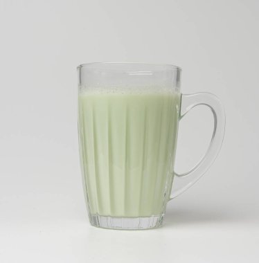 Bardakta vanilyalı milkshake. Beyaz arka planda izole edilmiş nane likörü, yeşil kivi smoothie, meyvelerle harmanlanmış sağlıklı badem sütü.