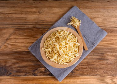 Passatelli spatzle makarna kasede, çiğ spaetzle noodle, ev yapımı Alman makarnası, ahşap masa arkasında sahanda yumurta makarna.