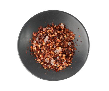Chili ve tuz çeşnili yalıtılmış, kırmızı kırmızı biberli baharat tozu küçük tabakta, ezilmiş acı biber taneleri ve beyaz arka planda tohumlar.