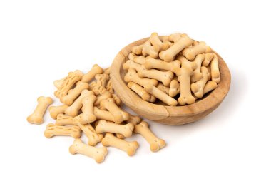 Tahta kasedeki köpek bisküvileri, yumuşak, çıtır çıtır evcil hayvanlar, aromalı küçük köpek kurabiyeleri, kemik şekilli bisküviler, beyaz arka planda köpek maması eğitimi.