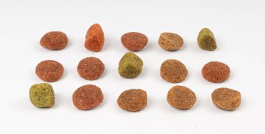 Kuru hayvan mamaları izole, köpek renginde mama yığını, köpek eti ve sebze topları, köpek proteini kroket yemeği, hayvan maması taneleri, beyaz arka planda kırmızı, yeşil ve kahverengi toplar.