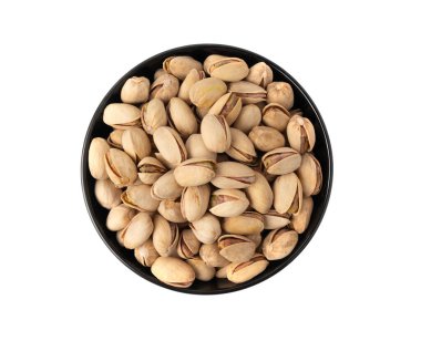 Siyah kasede kızartılmış şam fıstığı. Pişmiş şam fıstığı yığını, kavrulmuş yeşil şam fıstığı meyvesi kabuklu beyaz arka plan manzaralı