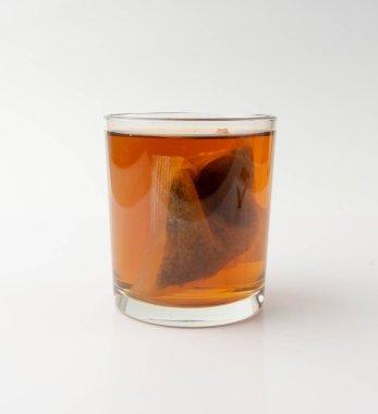 Bardakta bitki çayı kesesi, papatya çayı ve hiperikum ile sıcak su veya St. John 's Wort çay poşeti, tedavi amaçlı tıbbi içecek kupası, beyaz arka planda çay poşeti demleme süreci.