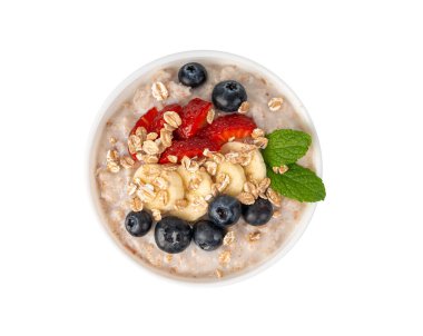 İzole edilmiş bir kasede pişirilmiş. Muz, çilek ve yaban mersinli yulaf ezmeli yulaf ezmesi, haşlanmış emmer ya da hecelenmiş sağlıklı tahıl gevreği. Pişmiş buğday, meyve ve müsli.