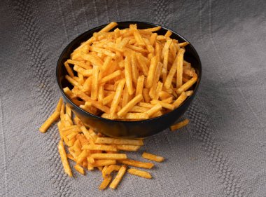 Kızarmış cips çubukları, patates kızartması siyah kasede ketçap aromalı patates kızartması, patates kızartması, patates kızartması, yakın plan.