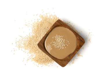 Tahini kasede izole edilmiş, susam tohumu ezmesi sürülmüş tahina sosu, doğu sosu, geleneksel doğu mutfağı malzemesi, beyaz arka planda yer susamı.